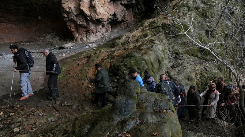 The team is guided through a cave by experienced mountaineers.