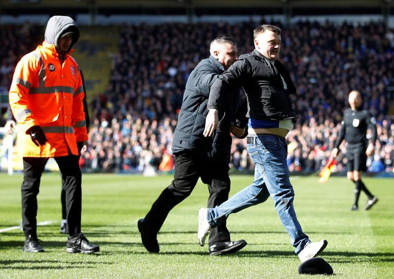 The fan that attacked Aston Villa's Jack Grealish is escorted off the pitch at St Andrew's/ Reuters