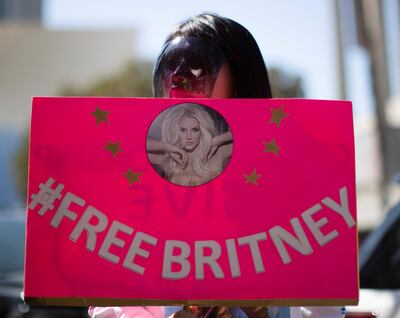 FILE PHOTO: A supporter wearing a personal protective face shield holds a sign while rallying for pop star Britney Spears during a conservatorship case hearing at Stanley Mosk Courthouse in Los Angeles, California, U.S., March 17, 2021.  REUTERS/Mario Anzuoni/File Photo