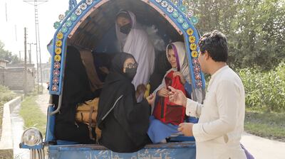 Arab Shah talks to schoolgirls on their way home on Darmangi Warsak Road, Peshawar. Tariq Ullah for The National