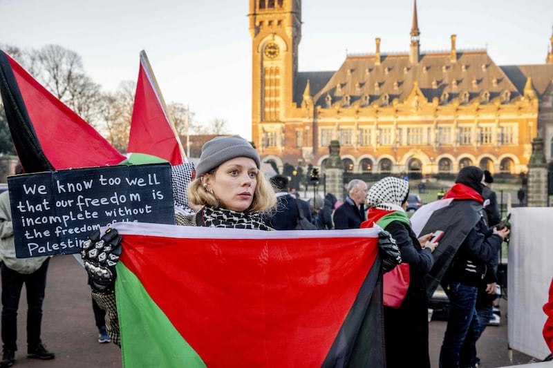 A protester holds a Palestinian flag outside the ICJ. AFP