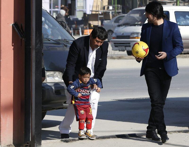 Five year-old Murtaza Ahmadi wears a shirt of Barcelona's star Lionel Messi as he arrives at the Football Federation headquarters in Kabul, Afghanistan February 2, 2016. Barcelona star Lionel Messi will meet an Afghan boy who gained Internet fame after a touching series of photographs went viral, showing him playing in a shirt improvised from a plastic bag and bearing the name and playing number of his hero. REUTERS/Omar Sobhani