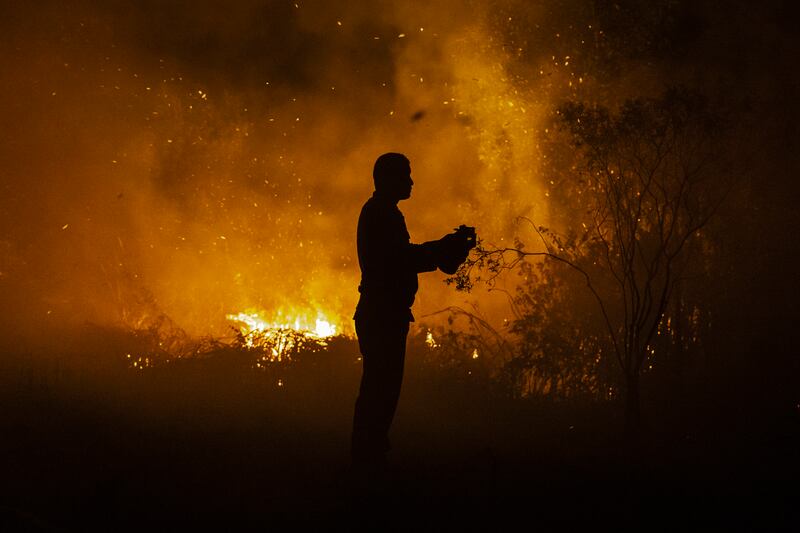 A firefighter tries to extinguish a wildfire on burned peatland and fields on September 23 in South Sumatra, Indonesia. Developing nations with a minimal carbon footprint have for years been bearing the brunt of increasing temperatures, extreme weather and rising sea levels. Getty