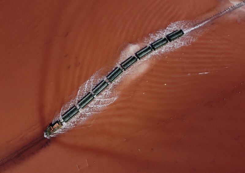 A train drives across a drained area for salt harvesting at Burlinskoye salt lake in the Altai Region, Russia. Reuters