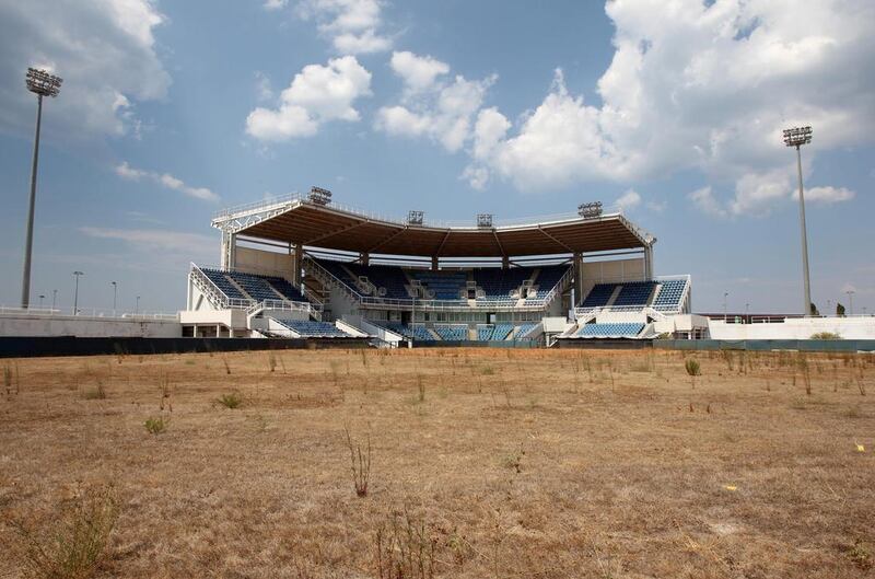 In this August 2, 2012 file photo, weeds sprout in the remains of what was once the playing field at the abandoned Olympic softball venue in southern Athens. The legacy of Athens’ Olympics has stirred vigorous debate, and Greek authorities have been widely criticized for not having a post-Games plan for the infrastructure. While some of the venues built specifically for the games have been converted for other uses, many are underused or abandoned, and very few provide the state with any revenue. Some critics even say that the multibillion dollar cost of the games played a modest role in the nation’s 2008 economic meltdown. Thanassis Stavrakis / AP Photo