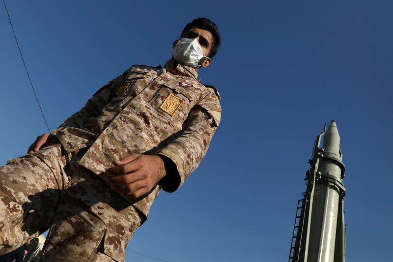 A soldier walks past an Iranian ballistic missile. AP
