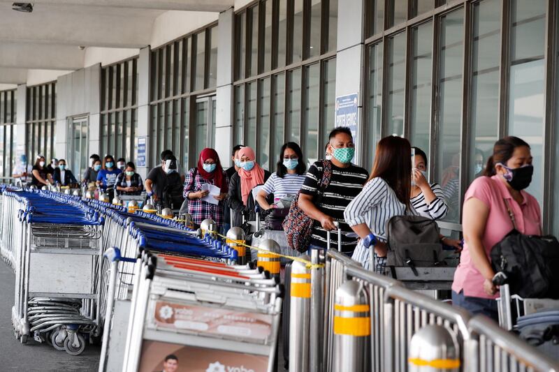 Passengers bound for Jeddah, Saudi Arabia line up for temperature check before entering the Manila International Airport terminal 1 in Parañaque. EPA