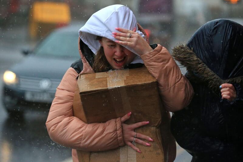 A woman tries to protect herself from the high winds and rain in Sheffield, northern England as Storm Ciara swept over the country.  AFP