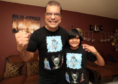 Father and son Man City fans Kaizad Mody and Keenan, 9, at home with a t-shirt they designed for the treble. Chris Whiteoak / The National