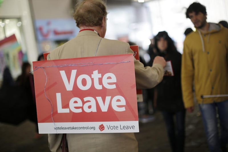 A "Vote Leave" campaigner wearing a placard around his neck distributes leaflets to members of the public in Manchester. Matthew Lloyd / Bloomberg