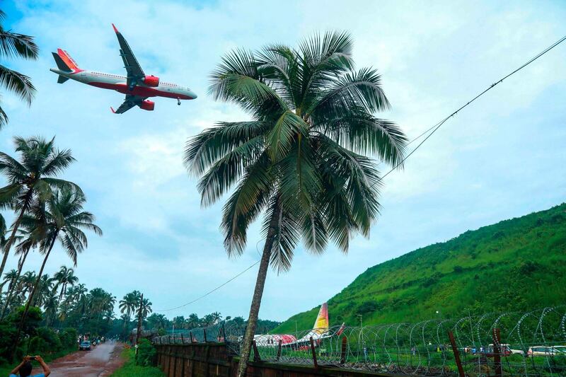 An aircraft approaches to land over the wreckage of an Air India Express jet at Calicut International Airport in Karipur, Kerala.  AFP