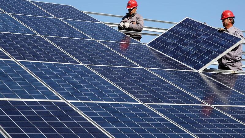 Workers install solar panels at a residential home. Reuters