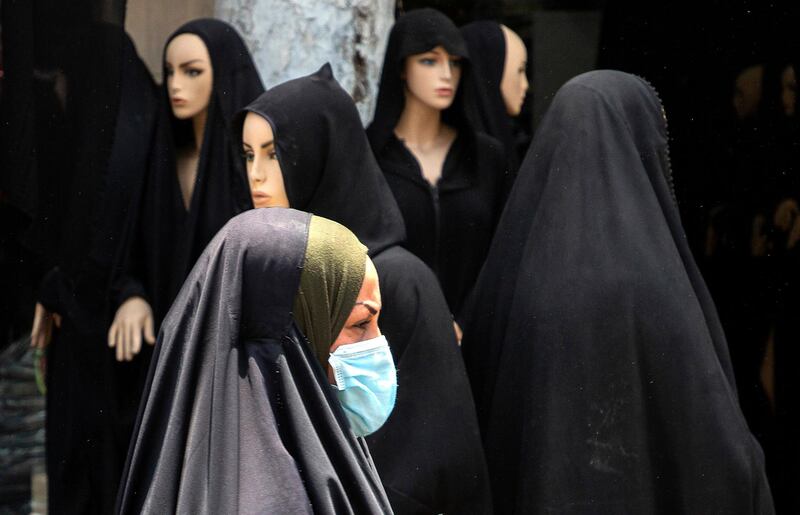 An Iraqi woman walks through a clothes market in the southern Iraqi city of Basra, ahead of Eid al-Fitr that marks the end of the Muslim fasting month of Ramadan, as some lockdown restrictions imposed during the novel coronavirus pandemic have been eased by the authorities. (Photo by Hussein FALEH / AFP)