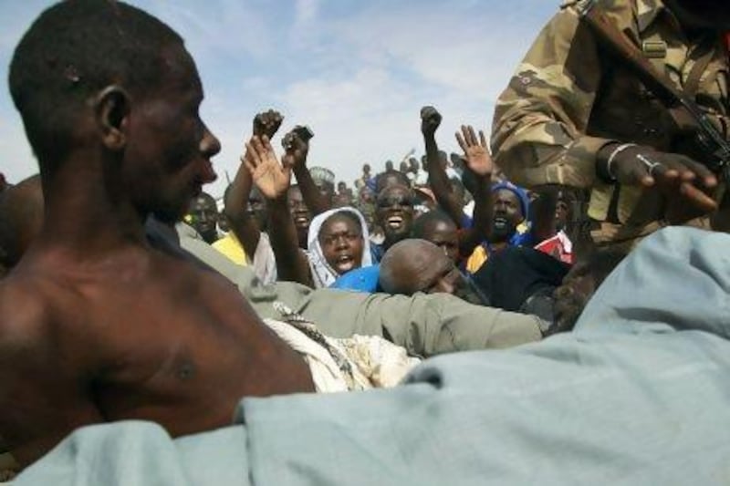 Angry crowds shout at suspected Islamist extremists in the back of an army truck in Gao, northern Mali. Mali soldiers prevented the mob from lynching them.