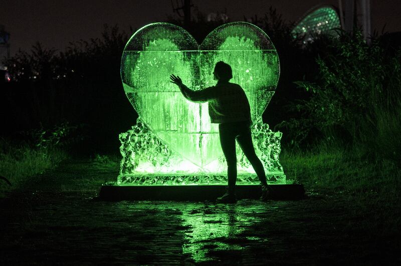 Stop Climate Chaos Scotland campaigners unveil a heart-shaped ice sculpture illuminated in green on the banks of the River Clyde overlooking the Cop26 summit venue. PA