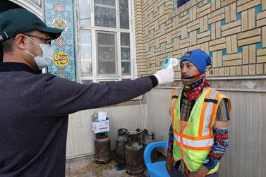A medic checks the temperature of a municipal worker in the city of Najaf in central Iraq. Reuters