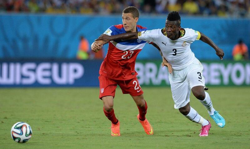 Asamoah Gyan tussles with US defender Fabian Johnson. Carl de Souza / AFP Photo