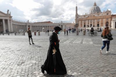 A priest wears a face mask as local authorities in the Italian capital Rome order face coverings to be worn at all times out of doors in an effort to counter rising coronavirus disease (COVID-19) infections, in Rome Italy October 12, 2020. REUTERS/Guglielmo Mangiapane