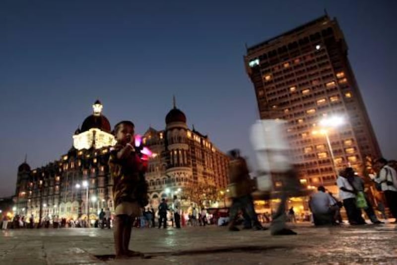 A boy stands in front of the Taj Mahal hotel, left, in Mumbai, India, Thursday, Oct. 28, 2010. U.S. president Barack Obama is scheduled to stay at this hotel during his visit to the city early next month. (AP Photo/Rajanish Kakade).  *** Local Caption ***  DEL129_India_US_Obama.jpg
