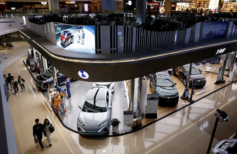 Electric vehicle models are on display at a shopping mall in Beijing. China has overtaken the US in terms of global unit sales of EVs. Reuters
