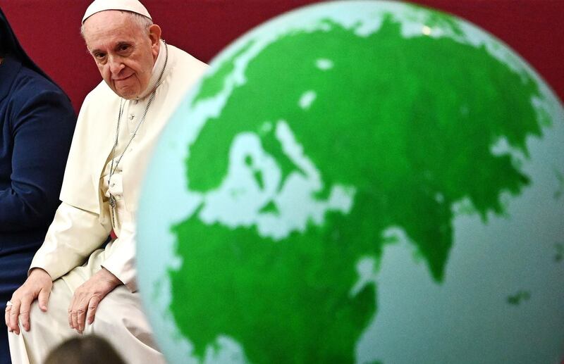 Pope Francis looks at a globe of the Earth during an audience for children and families of the Santa Marta dispensary on December 16, 2018 at the Vatican. / AFP / Vincenzo PINTO
