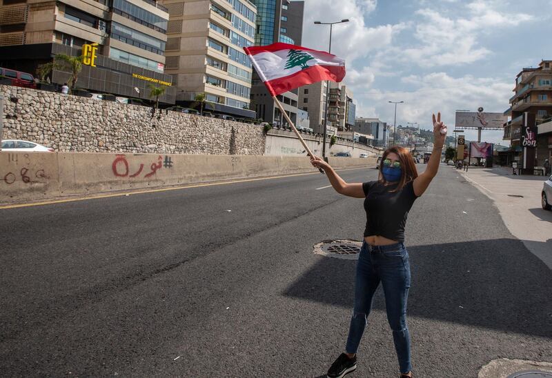 A supporter of Lebanese Christians parties stands in the midel of Highway, wave Lebanese flag during a protest against the collapsing Lebanese pound currency and the price hikes of goods, in Al-Zouk area, northern Beirut, Lebanon.  EPA