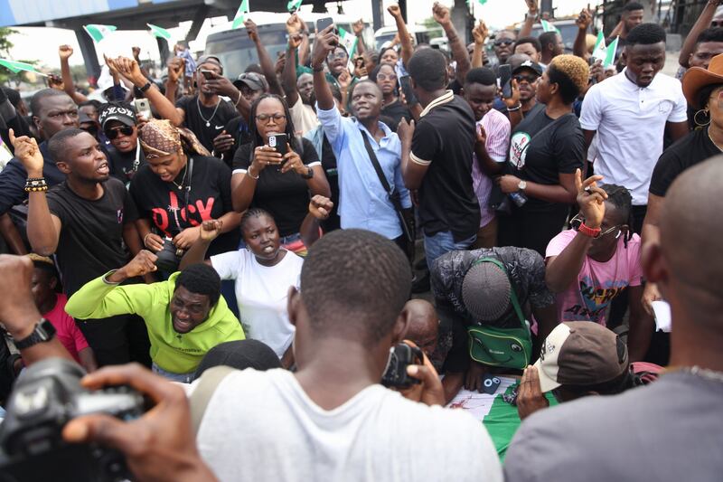 Protesters shout slogans on the road leading to the Lekki toll gate. EPA