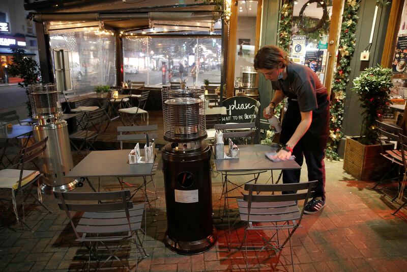 A waiter cleans a table at an empty restaurant in London. Authorities are still urging people to stay at home amid fears over the Omicron coronavirus variant. Reuters
