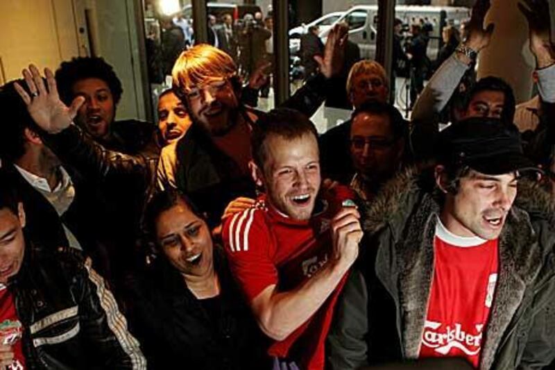 Liverpool fans celebrate in the offices of the law firm Slaughter and May after John W Henry announced his purchase of the club.
