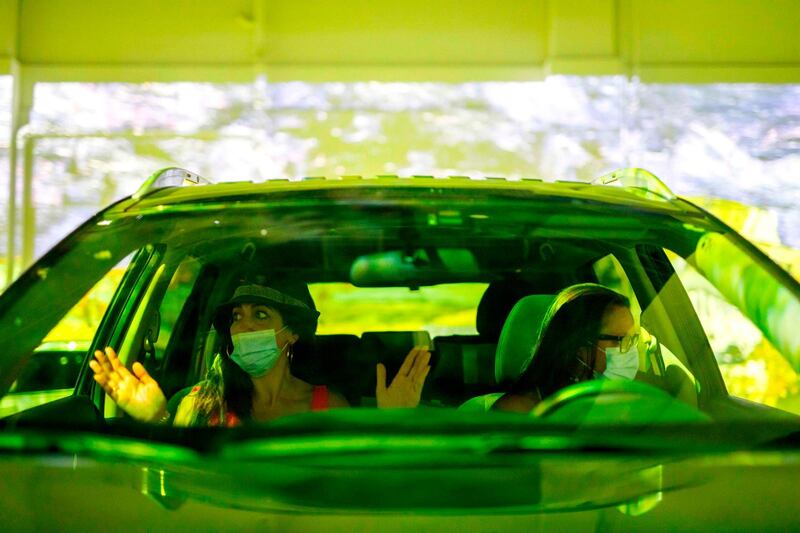 Joanna Christophi and her friend Lorraine Scholarchos sit in the car at the exhibition. AFP
