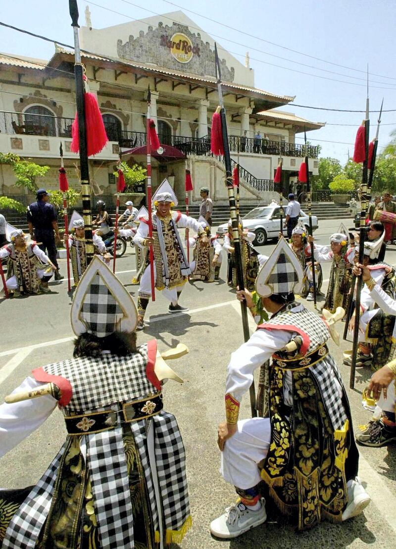 Indonesian dancers perform during a show in front of Hard Rock Cafe in the main street near the blast site of Kuta, some 15 km from the capital city of the resort island of Bali, Denpasar 24 October 2002. The Balinese artists made a long march and art performance along the street to show their respect for the 12 October bloody car bomb blast victims.  AFP PHOTO / Oka BUDHI (Photo by OKA BUDHI / AFP)