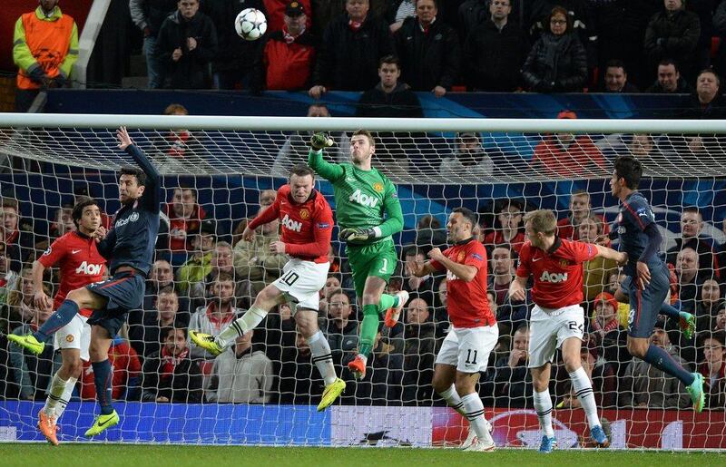 Manchester United goalkeeper David De Gea punches the ball clear from a crowded penalty area during Wednesday night's match against Olympiakos. Peter Powell / EPA / March 19, 2014