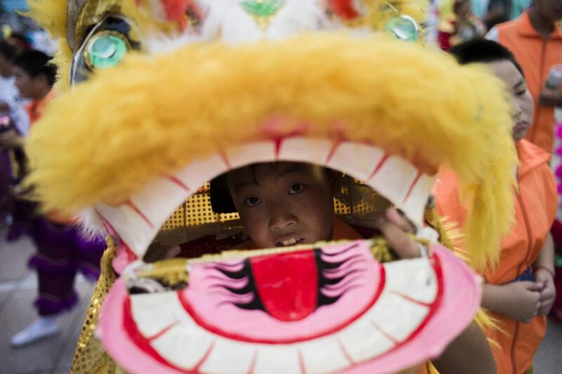 A young boy in a dragon costume parades among volunteers in Beijing after the announcement that Beijing had been named to host the 2022 Winter Olympic Games. Fred Dufour / AFP