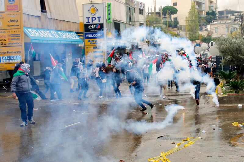 Protesters retreat from tear gas fired by riot police during a demonstration in front of the US embassy in Awkar, Lebanon, on December 10, 2017. Bilal Hussein / AP Photo