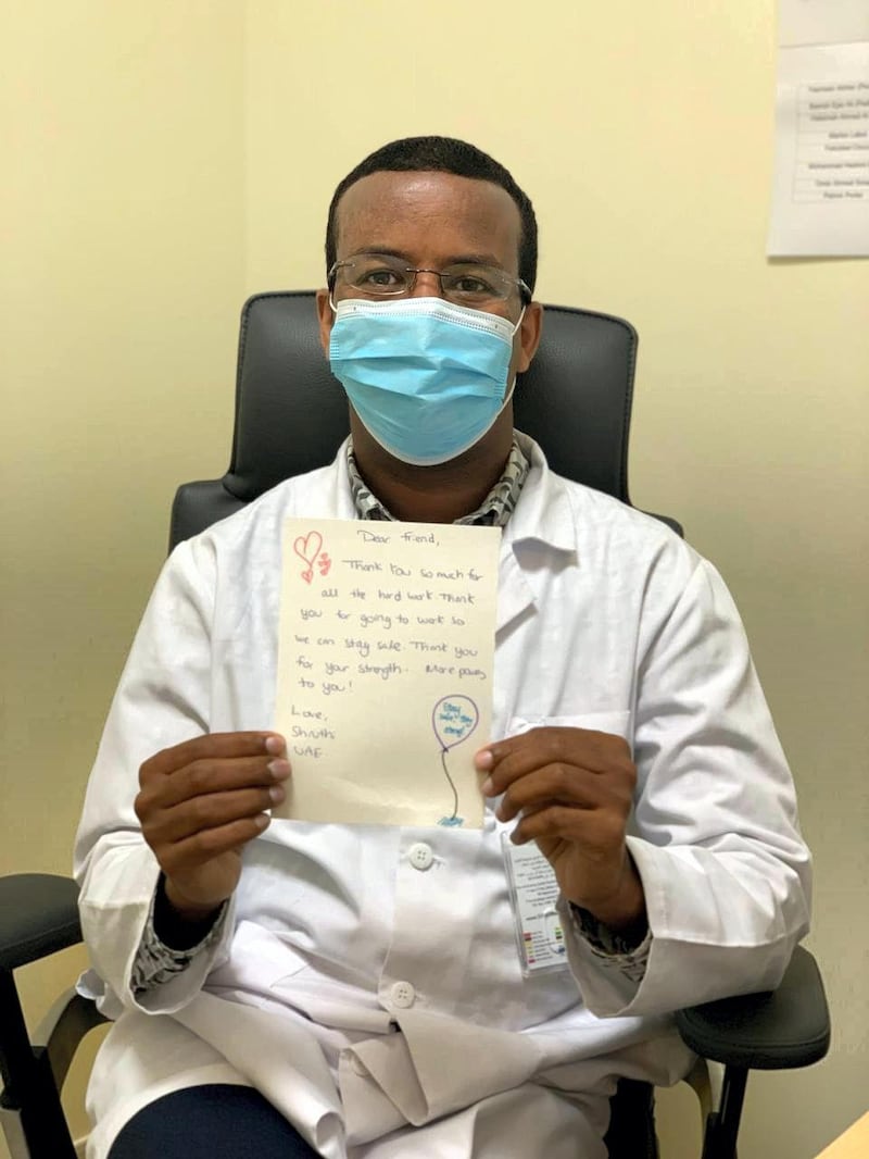 A doctor poses with the letter he received through the #DearHeroes project. Courtesy Seha