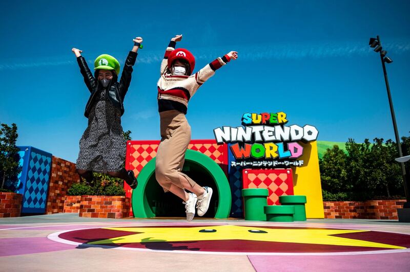 Fans of Universal Studio Japan pose at the entrance of the Super Nintendo World, during a media preview of the theme park in Osaka. AFP