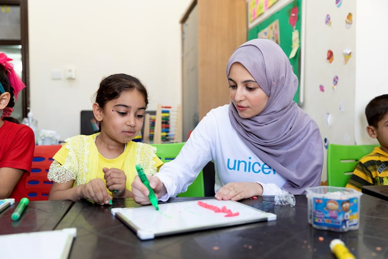 Muzoon Almellehan with Ahla, 8, during an Arabic learning support class in East Amman, Jordan. 
