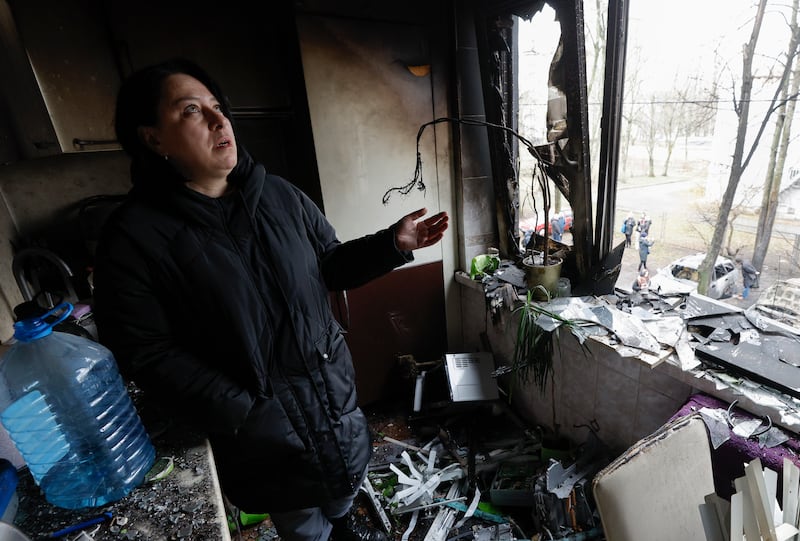 A woman looks at the damage in her flat after debris from a missile strike hit nearby, in Kyiv. EPA