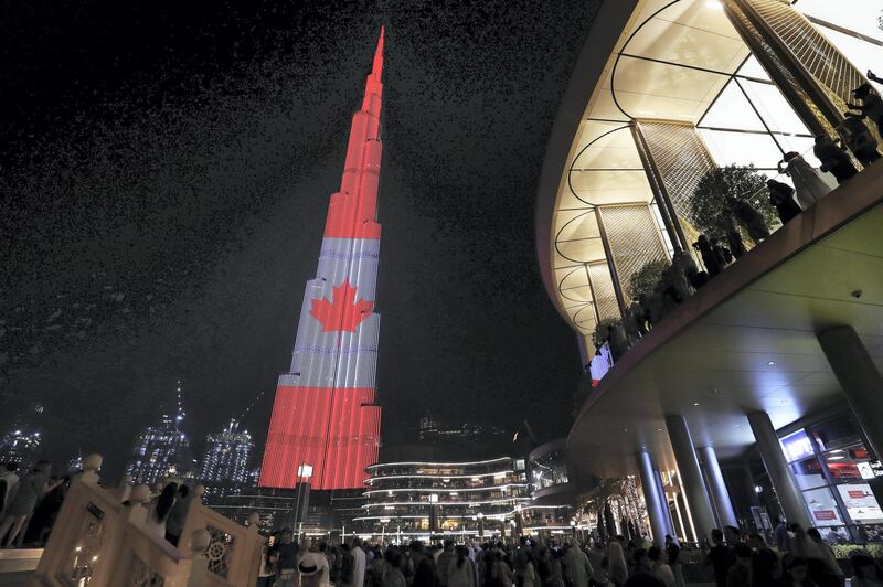 DUBAI ,  UNITED ARAB EMIRATES , JULY 1 – 2019 :- People gathered to see Burj Khalifa which is displaying a projection of the Canada Flag on the Canadian National Day at Dubai Mall in Dubai. ( Pawan Singh / The National ) For News