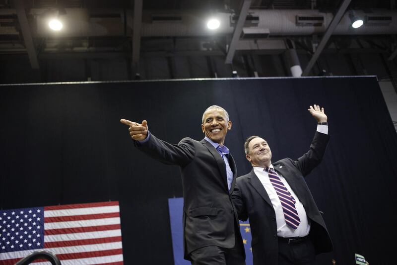Senator Joe Donnelly, a Democrat from Indiana, right, and Barack Obama gesture to attendees during a campaign rally in Gary, Indiana. Bloomberg