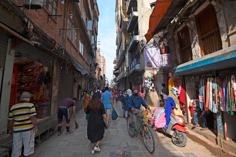 Pedestrians walk in a market in Kathmandu.  AFP