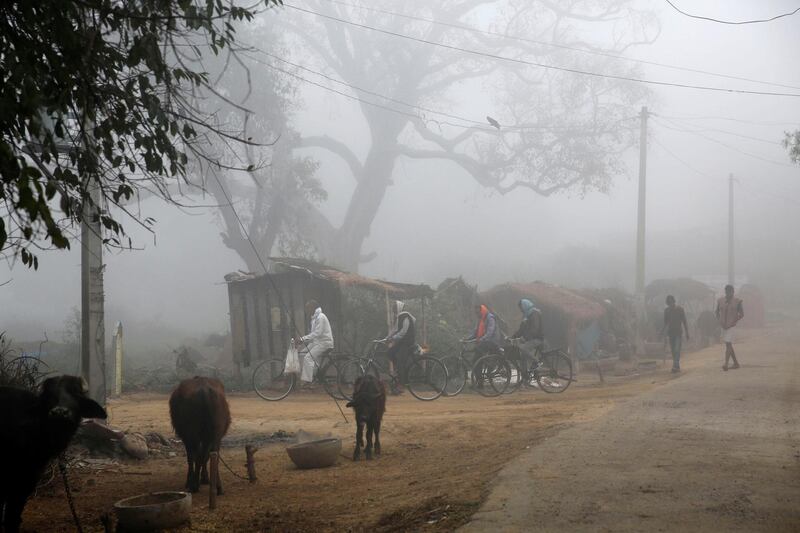 Indian villagers pedal the bicycles in the morning fog in Bandhwari Village, outskirts of Raebareli, Uttar Pradesh state, India, Sunday, March 8, 2020. (AP Photo/Rajesh Kumar Singh)