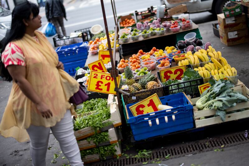 Grocery shopping at Whitechapel Road market in London. Inflation in the UK in May was unchanged at 8.7 per cent. EPA