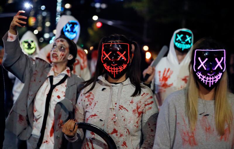 People dressed up in Purge costumes march during the parade. EPA