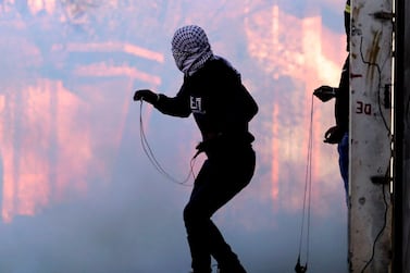 Palestinian protesters hurl stones at Israeli troops using slingshots during clashes with Israeli troops following a demonstration against the expropriation of Palestinian land by Israel, in the Israeli-occupied West Bank. AFP 