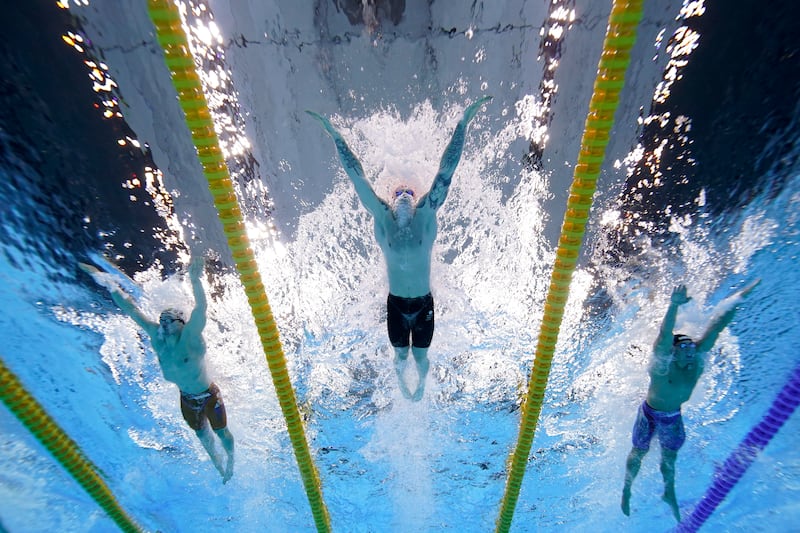 Britain's Adam Peaty, centre, swims to win the gold medal in the 100-metre breaststroke final.