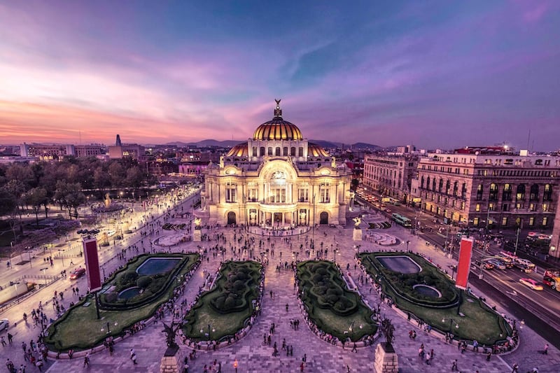 Fantastic view Mexico City's downtown at twilight. The nightlife of the city can be seen around the Palacio de Bellas Artes building in foreground. Courtesy Four Seasons