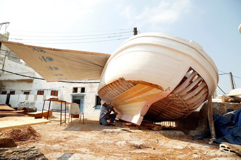 A man works on a boat on the island of Arwad, Syria.  Reuters