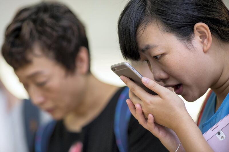 A customer tries the Siri voice recognition function on an Apple Inc. iPhone 6 Plus at the company's Causeway Bay store during the sales launch of the iPhone 6 and iPhone 6 Plus in Hong Kong, China, on Friday, Sept. 19, 2014. Apple stores attracted long lines of shoppers for the debut of the latest iPhones, indicating healthy demand for the bigger-screen smartphones. Photographer: Jerome Favre/Bloomberg