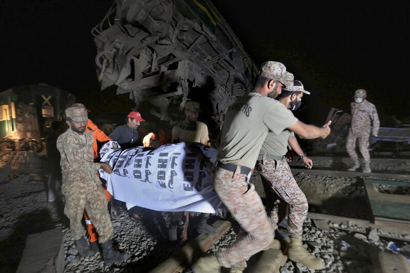 Soldiers and a rescue worker carry the body of a victim from the wreckage. AP